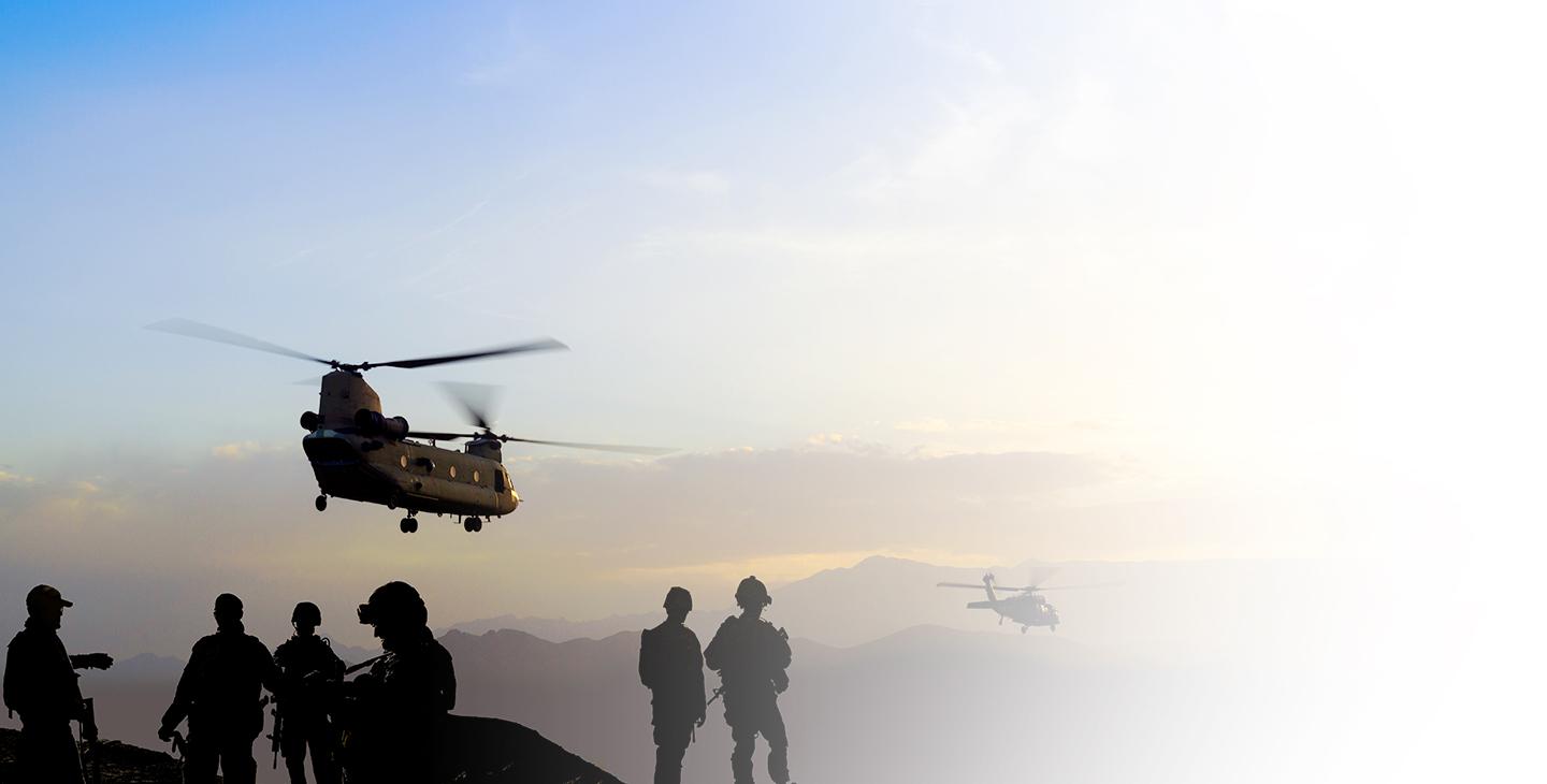 黄昏时分，两架直升机在战士的监视下飞过群山